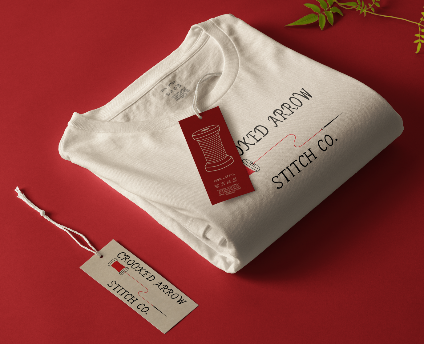A logo for the embroidery company, Crooked Arrow Stitch Co. The logo features handwritten letters alongside a red spool of thread and needle.